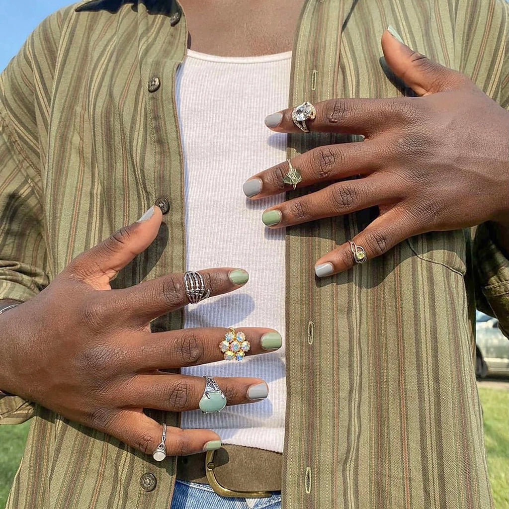 To Be Frank army green nail polish named Boot Camp and gray nail polish named Mood painted on African American man's hands
