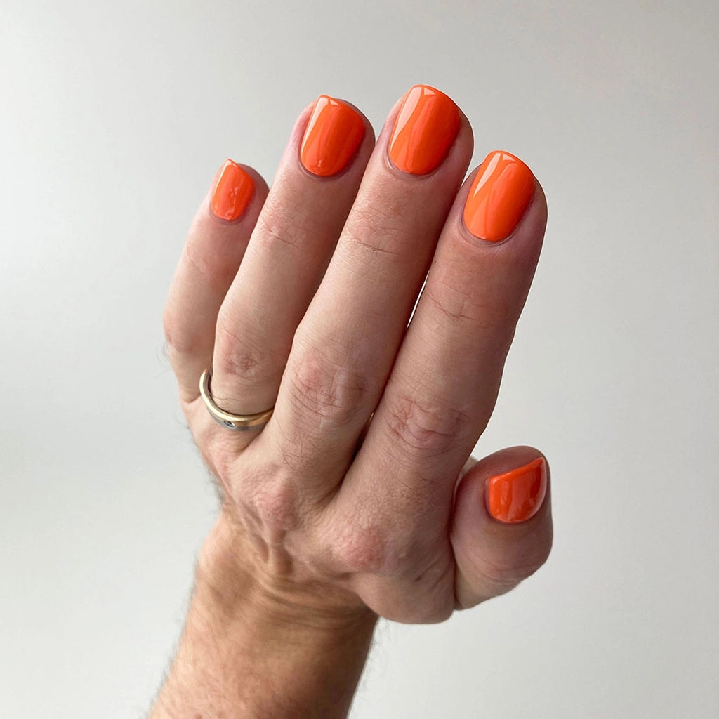 To Be Frank orange nail polish named Oh, Jay on man's hand