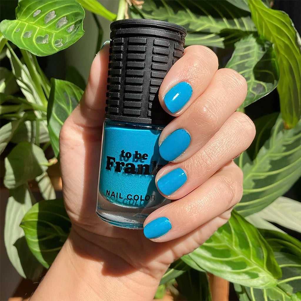 To Be Frank electric blue nail polish bottle with hand and painted short nails